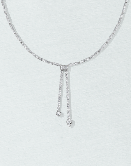 Birks Splash diamond lariat necklace on a blue background.